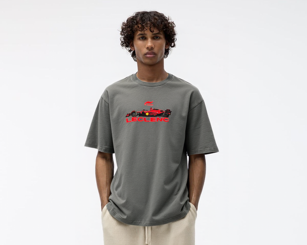 Person wearing a gray t-shirt with a logo and beige pants on a white background