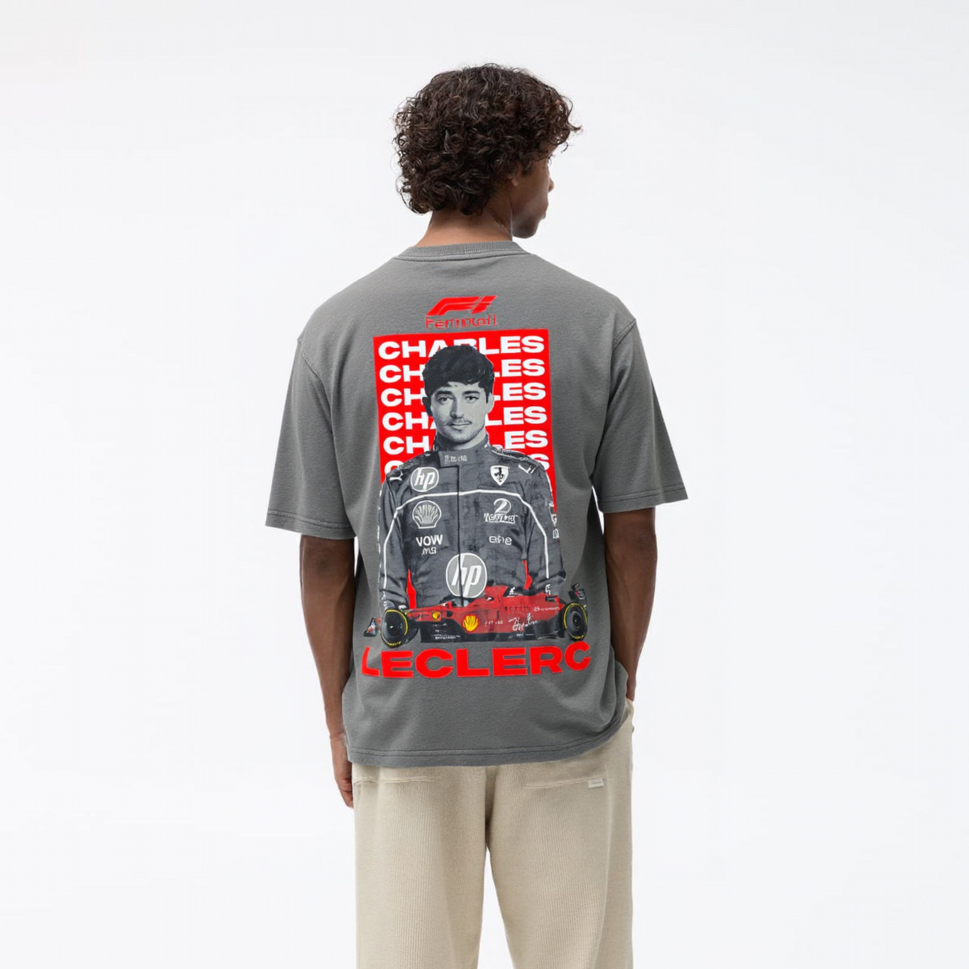 Person wearing a gray t-shirt with a graphic design on the back, standing against a white background